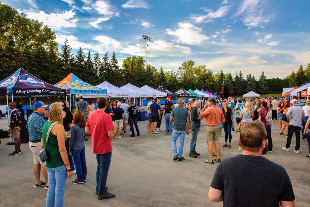 Attendees enjoying Tapped & Uncorked outdoor beer festival with vendor tents